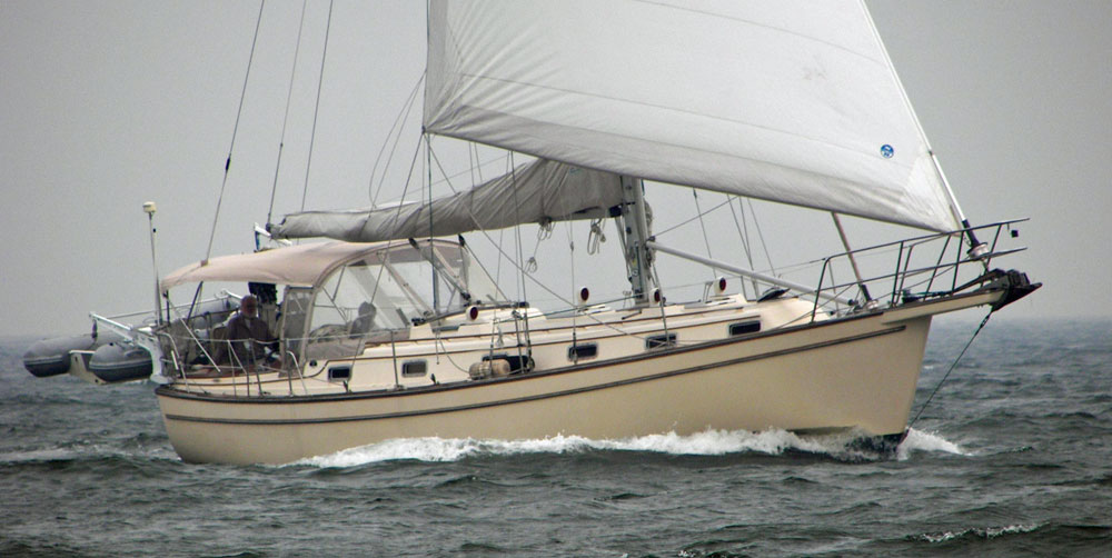 An IP38 sailboat sailing under headsail alone