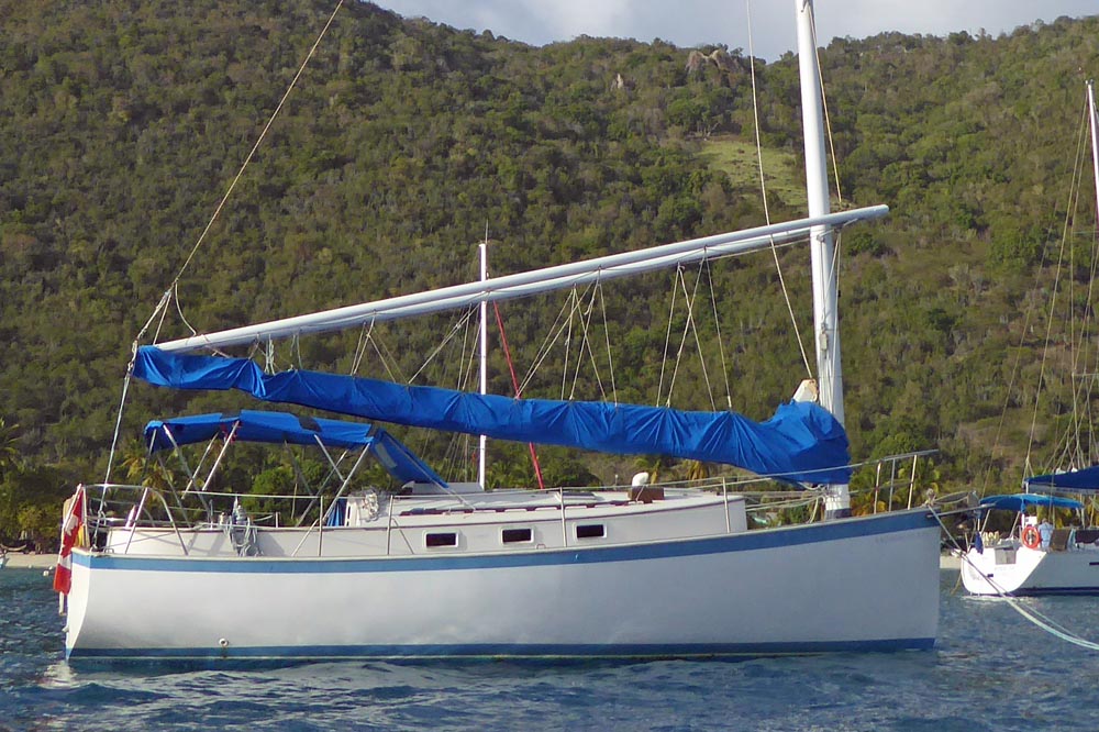 The Nonsuch 30, a Catboat with a wishbone rig and unstayed mast at anchor in Falmouth Harbour, Antigua.