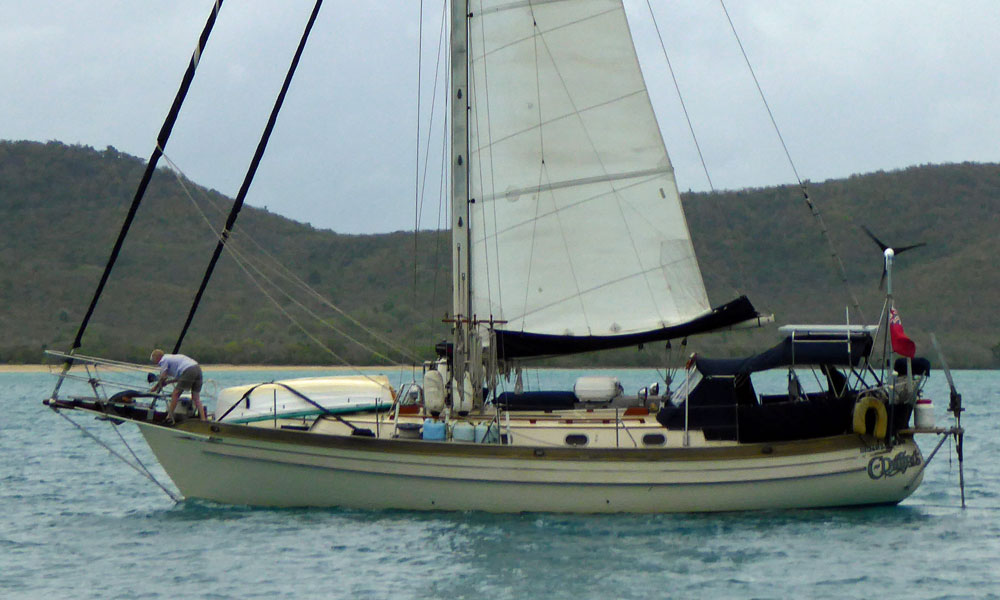 A heavy displacement, canoe-sterned Tashiba 40 cutter preparing to drop the hook in Five Islands Bay, Antigua.