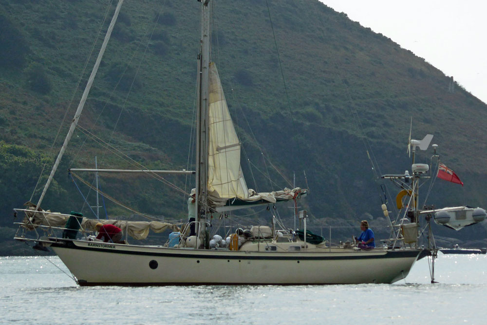 'Barnstormer', a Tradewind 35 heavy displacement cruising yacht at anchor under Jennycliff in Plymouth Sound, UK