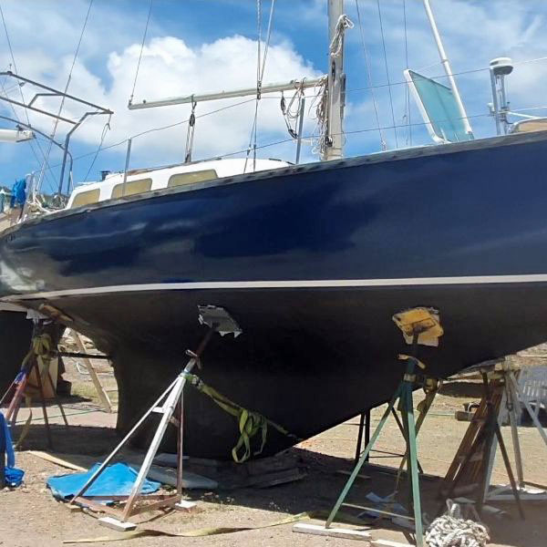 A Van de Stadt 30 sailboat ashore in a boatyard