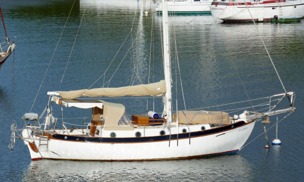 A Westsail 32 sailboat secured to a mooring ball