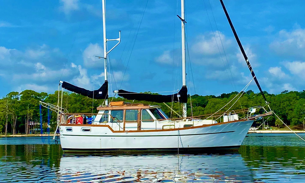 A Nauticat 33 liveaboard cruising yacht lying peacefully at anchor.