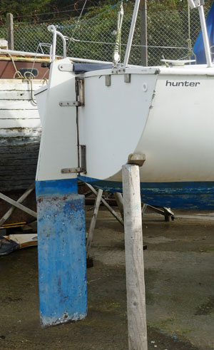 An outboard rudder hung on the transom of a light-displacement sailboat.