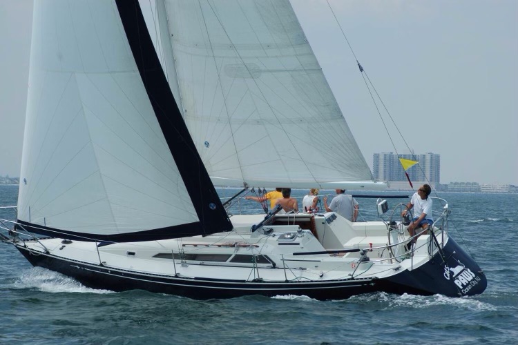 A C&C 34+ sailboat beats to windward under full sail
