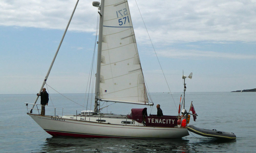 'Tenacity', a Contessa 32 cruising yacht on a windless day in Cawsand Bay, Plymouth, UK