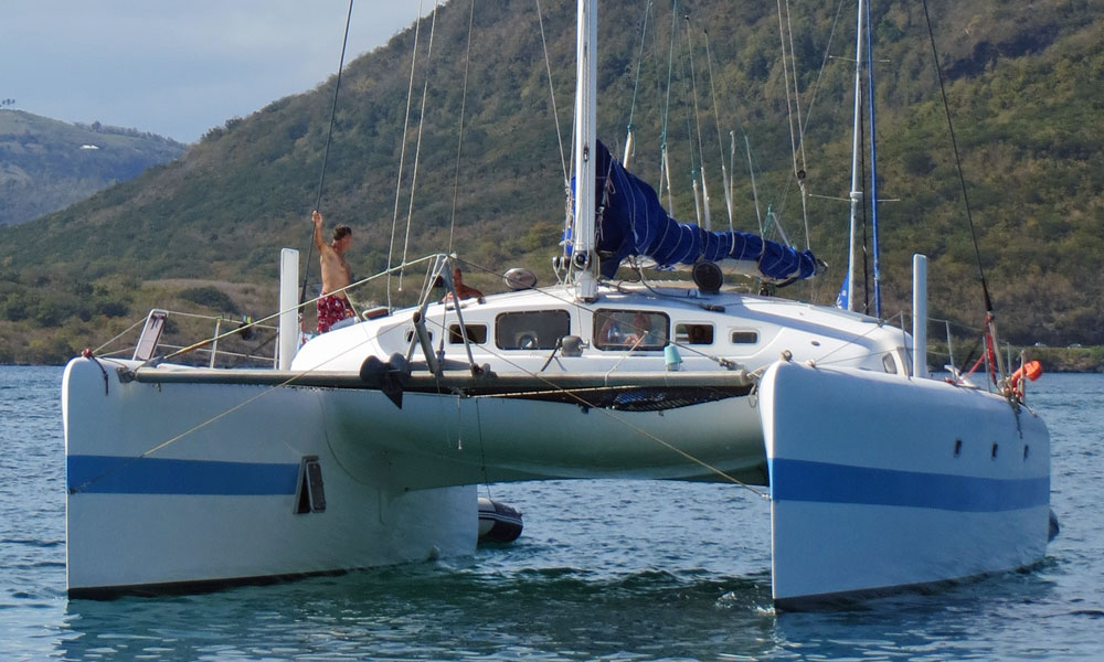 A high performance cruising catamaran with raised daggerboards and a partially open escape hatch.