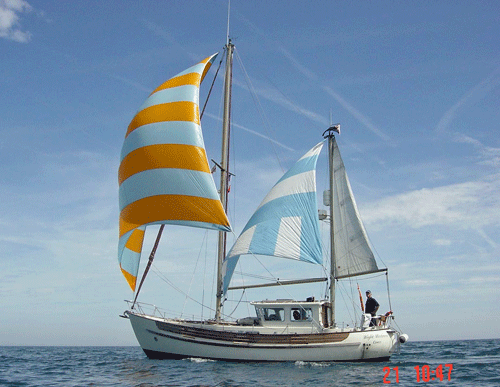 A Fisher 30 motorsailer ketch flying a cruising chute and a mizzen staysail