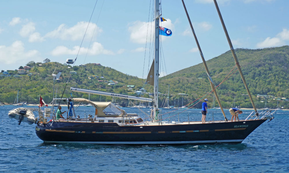 A Flying Dutchman 12 sailboat weighs anchor and departs Admiralty Bay, Bequia