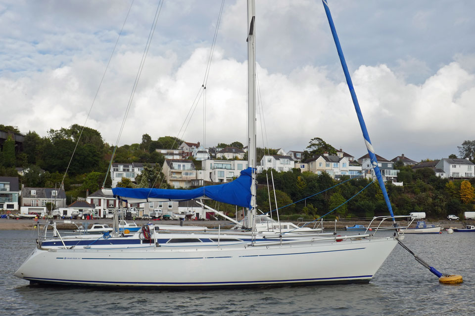 A Grand Soleil 343 sailboat moored on the UK's River Tamar with the Devon shore in the background
