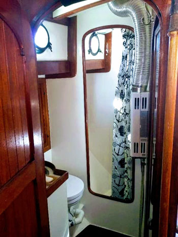 Spacious head with comfortable enclosed shower and on-demand hot water heater in this Hardin Seawolf ketch
