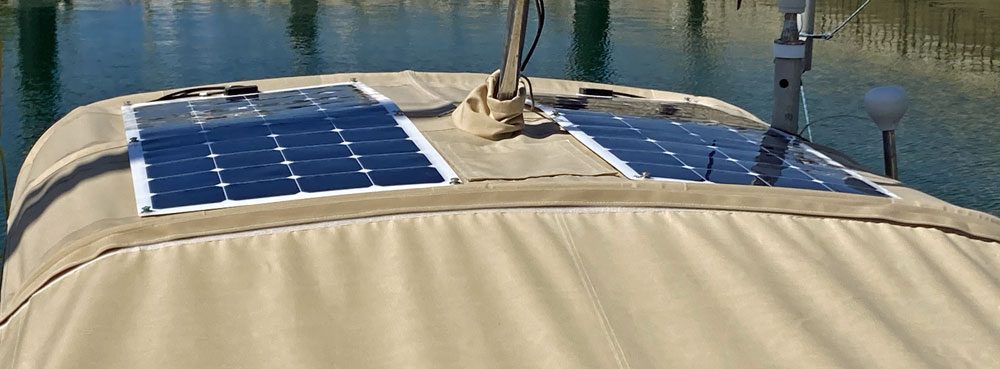 A pair of flexible solar panels on the bimini of a J/40 sailboat