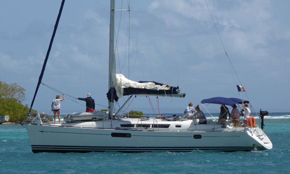 The crew of a Jeanneau Sun Odyssey 44 sailboat prepares to drop the hook