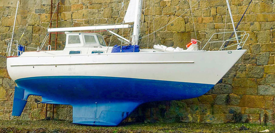 The Overseas 35 sailboat 'Svea by Valleviken’ dried out alongside a harbour wall