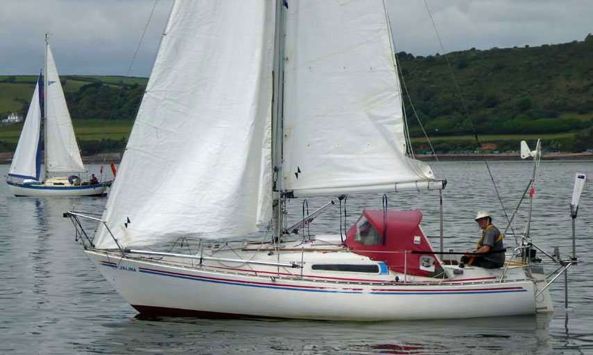 A Sadler 25 sailboat heads west out of Plymouth UK in light conditions