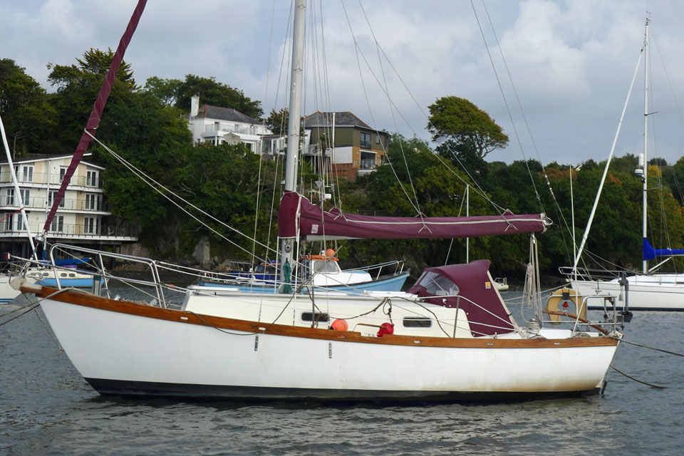 A Vertue 25 sailboat making way in a light wind