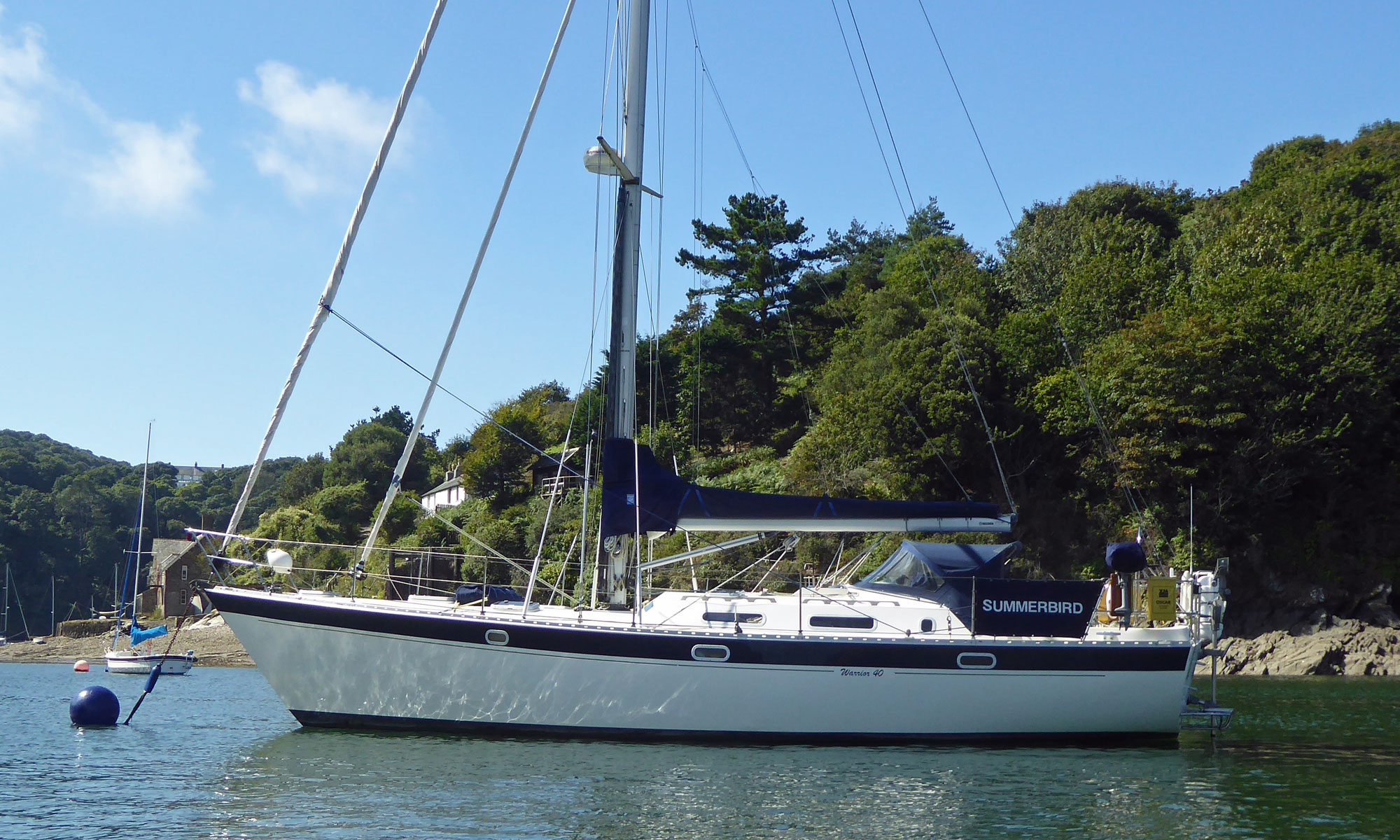 A Warrior 40 heavy displacement sailboat at anchor on Devon's River Yealm estuary.